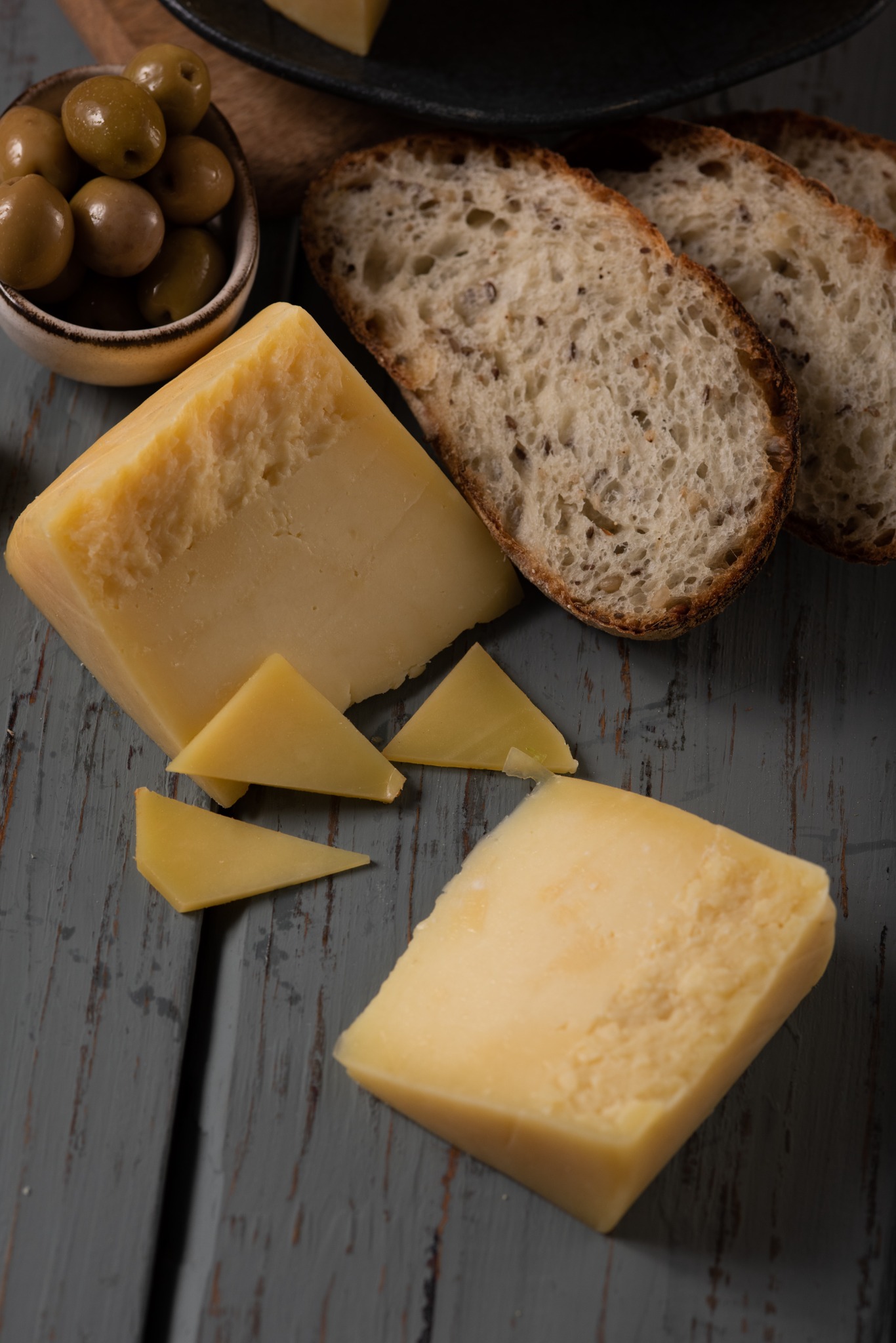 Queso, pan y aceitunas para preparar tostadas